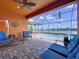 Covered patio featuring brick pavers, comfortable seating, ceiling fan and view of the pool and lake at 11614 Ashton Field Ave, Riverview, FL 33579