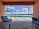 View of the pool from the covered patio featuring brick pavers, comfortable seating, and a view of the lake at 11614 Ashton Field Ave, Riverview, FL 33579