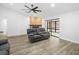 Cozy living room with a stone fireplace, ceiling fan, and sliding glass doors at 12546 108Th St, Largo, FL 33778