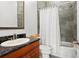 Bathroom with a black countertop sink, a mirror with an ornate frame, and a bathtub behind a white shower curtain at 131 Miramar Ne Blvd, St Petersburg, FL 33704