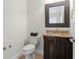 Powder bathroom boasts dark wood cabinet, granite countertop, framed mirror and decorative tile at 131 Miramar Ne Blvd, St Petersburg, FL 33704