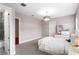 A well lit bedroom with light purple walls, carpeted floors, and a connected bathroom with a tile shower at 131 Miramar Ne Blvd, St Petersburg, FL 33704