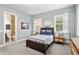 A bedroom with a dark brown bed frame, two windows letting in light, and a bathroom with tiled walls visible at 131 Miramar Ne Blvd, St Petersburg, FL 33704