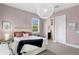 Bedroom featuring pastel pink walls, a unique light fixture, and a door that leads to the bathroom at 131 Miramar Ne Blvd, St Petersburg, FL 33704