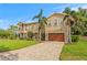 Elegant two-story home featuring a paver driveway, lush lawn, and a spacious two-car garage at 131 Miramar Ne Blvd, St Petersburg, FL 33704