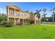 Stunning two-story home featuring a well-manicured lawn, mature palms, and charming architectural details at 131 Miramar Ne Blvd, St Petersburg, FL 33704