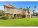 Grand two-story home featuring a manicured lawn, palm trees, a two-car garage, and elegant architectural details at 131 Miramar Ne Blvd, St Petersburg, FL 33704