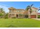 Expansive two-story home with lush landscaping, mature palm trees, balconies, and a front-facing two-car garage at 131 Miramar Ne Blvd, St Petersburg, FL 33704