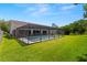 A spacious backyard featuring a screened in pool area, with lush green grass, perfect for outdoor gatherings at 14164 Fennsbury Dr, Tampa, FL 33624