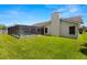 Expansive backyard with a screened pool, well-manicured lawn, and a neutral-colored exterior, ideal for outdoor living at 14164 Fennsbury Dr, Tampa, FL 33624