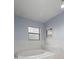 Bright bathroom with white tiled walls, jacuzzi tub and window providing natural light in a neutral toned room at 14164 Fennsbury Dr, Tampa, FL 33624