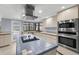 Kitchen area featuring a cooktop island, stainless appliances and exterior access door at 14164 Fennsbury Dr, Tampa, FL 33624