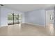 Open-concept living room with large sliding doors leading to a screened pool and neutral-toned tile flooring at 14164 Fennsbury Dr, Tampa, FL 33624