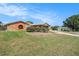 Expansive front yard with meticulously manicured lawn, mature landscaping, and a charming brick pathway leading to the house at 159 Canby Cir, Spring Hill, FL 34606