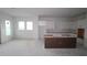 Spacious kitchen with white cabinetry, brown island, and plenty of natural light awaiting final installation at 1614 Running Tide Pl, Sarasota, FL 34240
