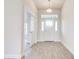 Welcoming entryway with wood-look tile flooring, white trim, and a modern light fixture at 16425 66Th E Ln, Parrish, FL 34219