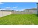 Expansive, green backyard enclosed by a pristine white fence, offering ample space for recreation and relaxation at 1829 Draughton Dr, Zephyrhills, FL 33541