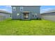 Large backyard with a sliding glass door to the home's rear at 1829 Draughton Dr, Zephyrhills, FL 33541