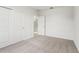 A bedroom features a neutral carpet, bright white walls, and double closet doors at 1829 Draughton Dr, Zephyrhills, FL 33541