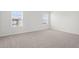 A bedroom features neutral carpet, bright white walls, trim, and two windows with blinds at 1829 Draughton Dr, Zephyrhills, FL 33541