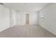 A bedroom features neutral carpet, white walls, trim, and a view to the outside at 1829 Draughton Dr, Zephyrhills, FL 33541