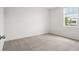 A bright bedroom features neutral carpet, white walls, trim and a window with blinds at 1829 Draughton Dr, Zephyrhills, FL 33541