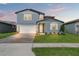 Charming two-story home featuring a beautifully landscaped front yard and a brick driveway leading to the garage at 1829 Draughton Dr, Zephyrhills, FL 33541