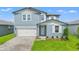 Charming two-story home featuring a beautifully landscaped front yard and a brick driveway leading to the garage at 1829 Draughton Dr, Zephyrhills, FL 33541