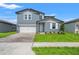 Charming two-story home with a two-car garage, landscaped yard, and inviting entrance at 1829 Draughton Dr, Zephyrhills, FL 33541