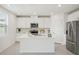 Modern kitchen featuring white cabinetry, stainless steel appliances, and a spacious center island at 1829 Draughton Dr, Zephyrhills, FL 33541