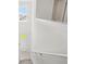 Bright view of front door from carpeted stairs with white walls and railing at 1829 Draughton Dr, Zephyrhills, FL 33541