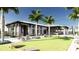 Exterior of the clubhouse showing an outdoor bar area, and grassy lawn for yard games at 18421 Vista Park Ter, Venice, FL 34293