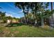 Expansive backyard features a decorative fence, mature trees, and lush green grass at 2020 58Th N Way, Clearwater, FL 33760