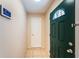 Welcoming entryway featuring a green front door, light tile flooring, and a smart home system on the wall at 2020 58Th N Way, Clearwater, FL 33760