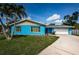 Bright blue single-story home with a well-maintained lawn and a palm tree in the front yard at 2020 58Th N Way, Clearwater, FL 33760