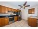 Modern kitchen with stainless steel appliances, oak cabinets, granite countertops, and tile flooring at 2020 58Th N Way, Clearwater, FL 33760