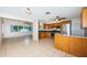 Open kitchen with stainless steel appliances, oak cabinets, granite countertops, and tile flooring throughout at 2020 58Th N Way, Clearwater, FL 33760