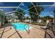 Relaxing screened-in pool area with sunbathing deck, lounge chair, and lush green landscaping at 2020 58Th N Way, Clearwater, FL 33760