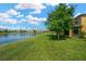 Serene view of the pond from the lush green lawn with mature trees at 2022 Hawks View Dr, Ruskin, FL 33570