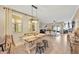 Open-plan dining area with rustic table and view of the living area and lots of natural light at 2022 Hawks View Dr, Ruskin, FL 33570