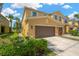 Inviting townhome featuring a two-car garage, manicured landscaping, and a warm, neutral color palette at 2022 Hawks View Dr, Ruskin, FL 33570