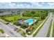 Aerial view of the community pool with surrounding neighborhood, green spaces and palm trees at 2022 Hawks View Dr, Ruskin, FL 33570