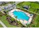 A stunning aerial view of a community pool area with palm trees, lounge chairs, and inviting cabanas at 2022 Hawks View Dr, Ruskin, FL 33570