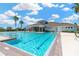 Community pool features clear blue water, palm trees, and comfortable lounge chairs at 2022 Hawks View Dr, Ruskin, FL 33570
