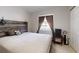 A simple bedroom with tile floors, neutral walls and a wooden headboard with minimalist decor accents at 22798 Penny Loop, Land O Lakes, FL 34639