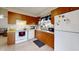 Bright kitchen featuring wooden cabinetry, tile floors, a white stove and dishwasher for a functional cooking space at 22798 Penny Loop, Land O Lakes, FL 34639