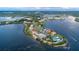 Aerial view of waterfront homes on an island with surrounding waterways and lush greenery at 26 Harborpointe Dr, Port Richey, FL 34668