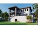 A contemporary-style home featuring a multi-level design, balconies, and lush tropical landscaping at 26 Harborpointe Dr, Port Richey, FL 34668