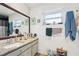 Bright bathroom with updated vanity, white plank walls, and decorative mirror at 2714 Witley Ave, Palm Harbor, FL 34685