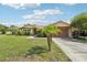 Charming single-story home featuring a well-manicured lawn, mature trees and a cozy two-car garage at 2714 Witley Ave, Palm Harbor, FL 34685